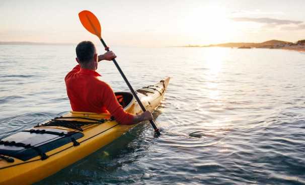 kayaker on lake facing the sunrise